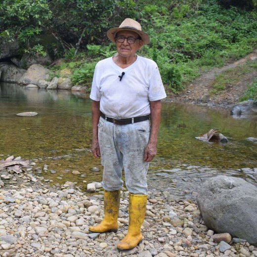 Carlos Modesto Cuenca standing by a river on his farm